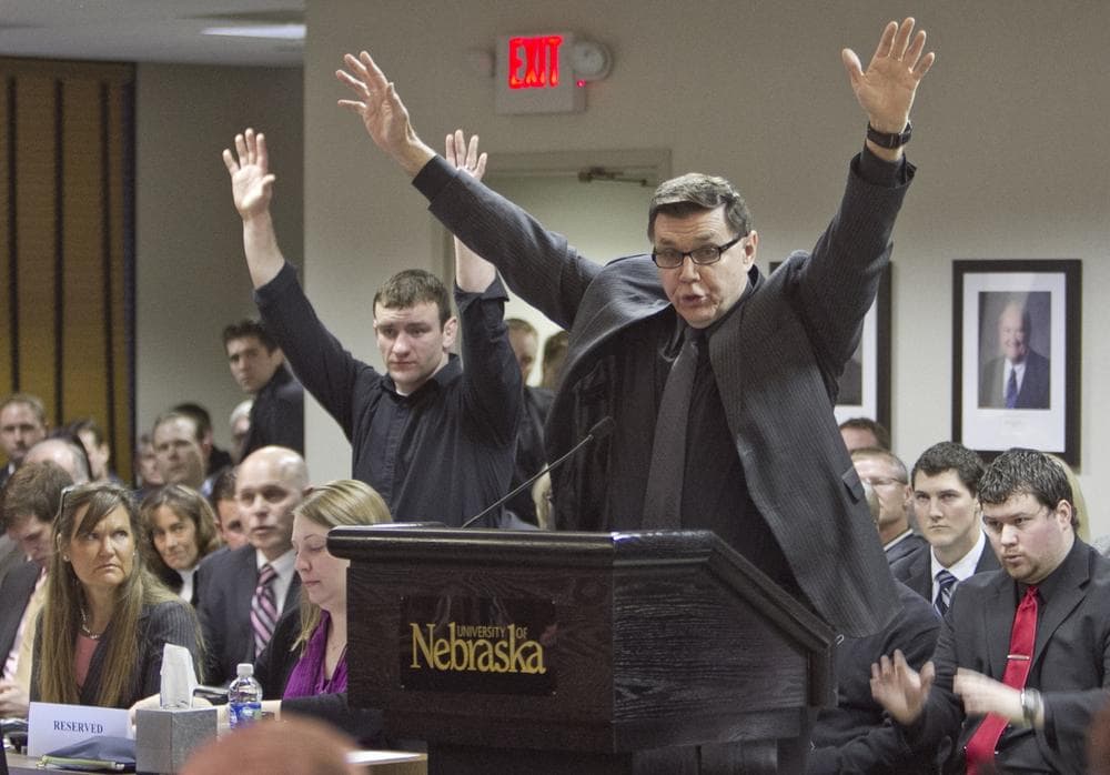 University of Nebraska at Omaha wrestling coach Mike Denney lifts his arms in protest as university regents unanimously approved the UNO's proposal to join the NCAA Division I Summit League. The move from Division II eliminates UNOs' football and wrestling programs. (AP)