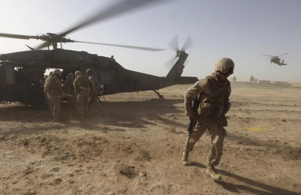 U.S. Marines help a wounded comrade onto a Black Hawk helicopter, left, during a medevac mission by the U.S. Army's 82nd Airborne's Task Force Pegasus, in 2010.  (AP)