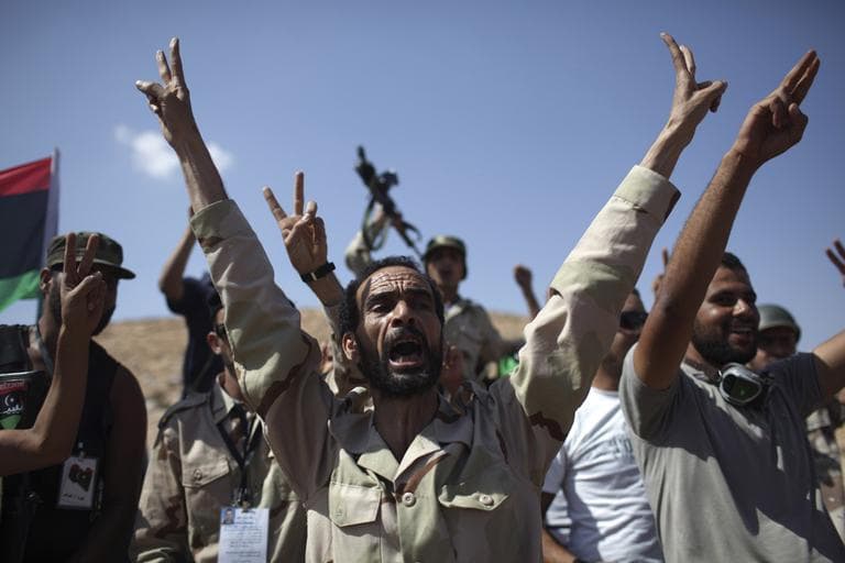 Rebel fighters shout slogans against Moammar Gadhafi at a checkpoint between Tarhouna and Bani Walid, Libya, Wednesday. (AP)