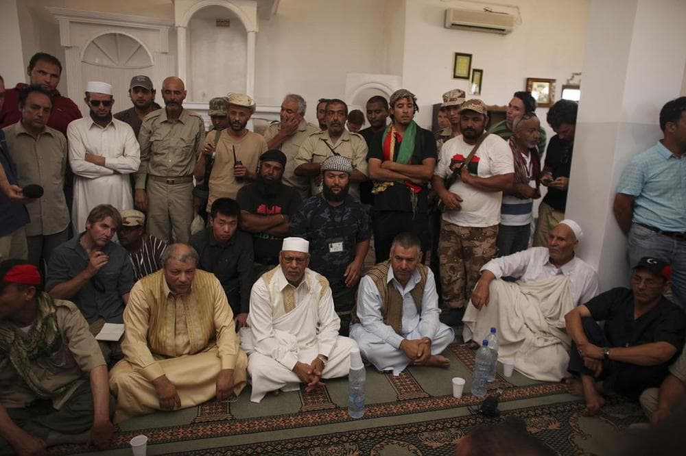 Tribal elders, bottom, speak to Abdalla Kenshil, chief rebel negotiator, in a mosque at a checkpoint between Tarhouna and Bani Walid on Tuesday. (AP)