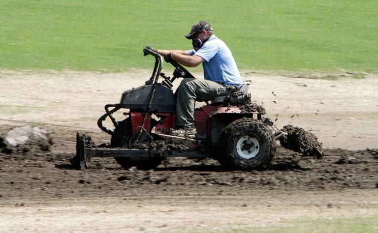 Following Tropical Storm Irene, Scott Burton tries to move mud off the golf course at the Woodstock Inn resort on Friday in Woodstock, Vt., near West Hartland, Vt. (AP)