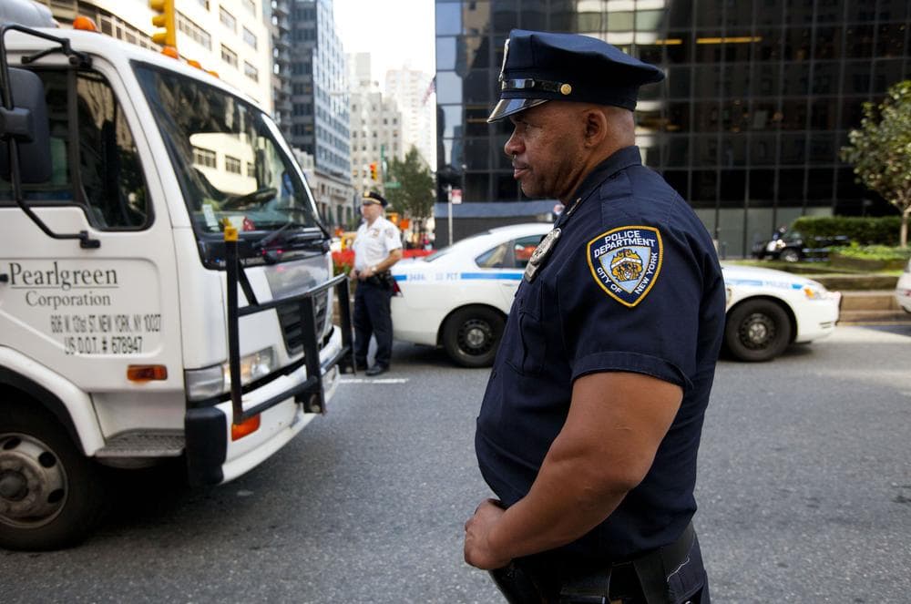 A New York City police officer checks vehicles passing on 59th street and Park Avenue at a vehicle checkpoint on Friday. (AP)