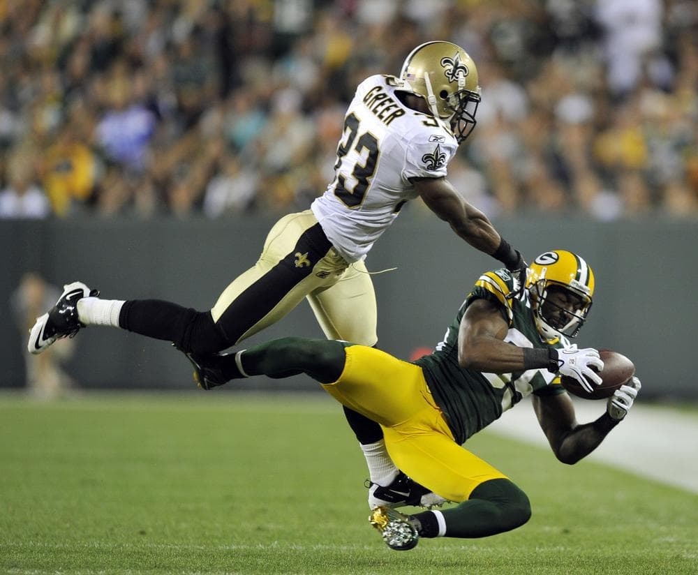 Greg Jennings of the Green Bay Packers catches a pass in front of New Orleans Saints' Jabari Greer during the second half of the NFL season opener on Thursday night in Green Bay. (AP)