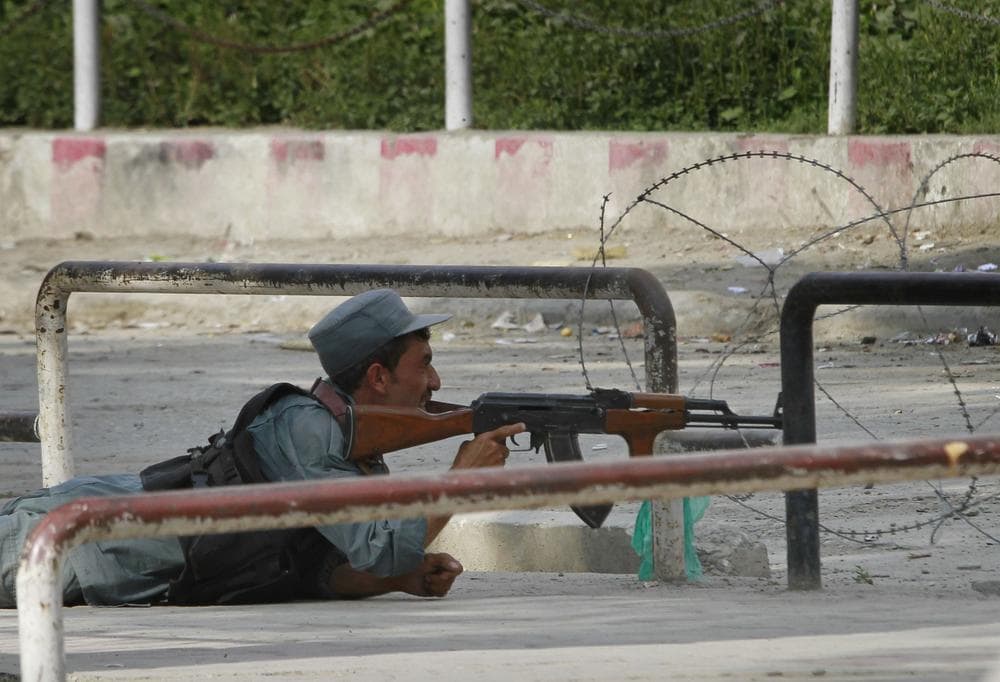 An Afghan policeman takes position near the building which is occupied by militants, unseen, in Kabul, Afghanistan on Tuesday. (AP)
