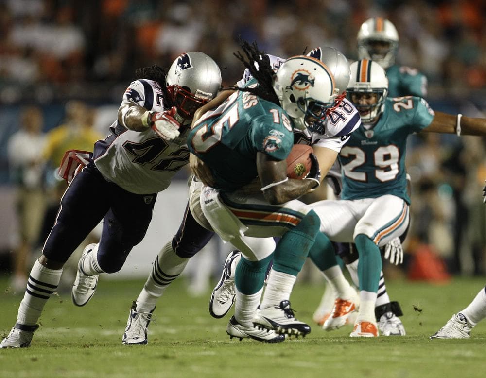 New England players Benjarvus Green-Ellis (42) and Danny Aiken (48) tackle Miami&#039;s Davone Bess (15) during the first half of the game in Miami on Monday. New England won 38-24. (AP)