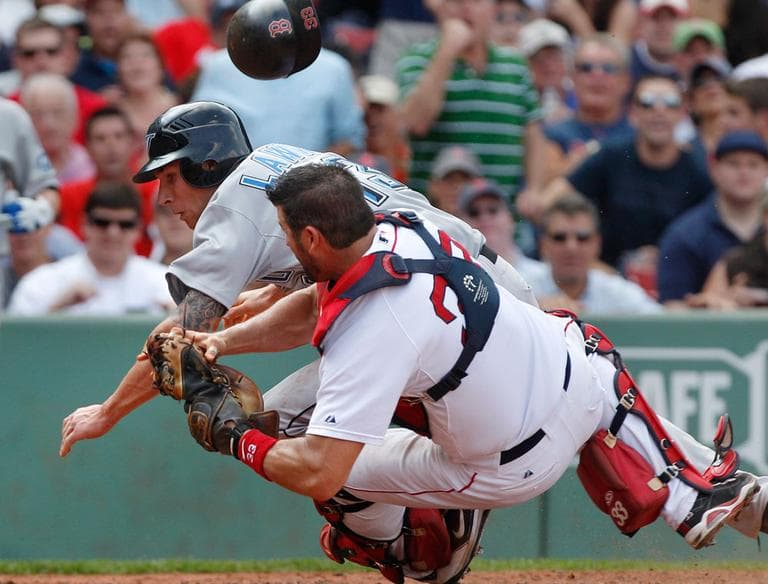 Sox catcher Jason Varitek loses his helmet but hangs onto the ball as he collides with Blue Jay Brett Lawrie, who unsuccessfully tried to score on a fielder's choice during the sixth inning Wednesday. (AP)