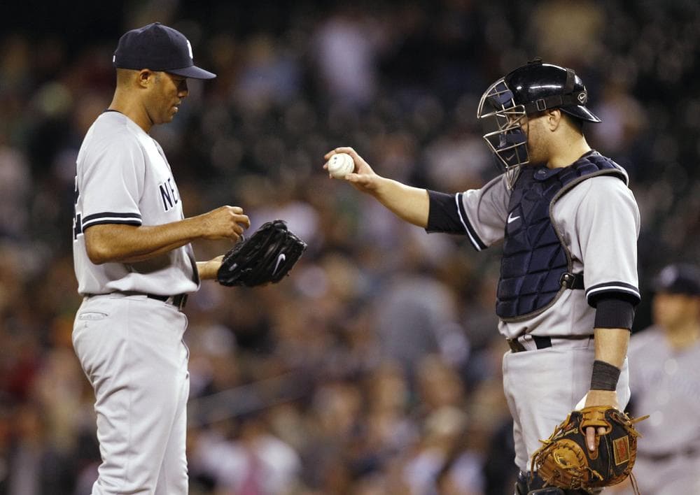 Yankees catcher Russell Martin hands the ball to closer Mariano Rivera as Rivera takes the mound against the Seattle Mariners on Tuesday night. The Yankees won 3-2 and Rivera earned his 600th save, moving within one of Trevor Hoffman's major league record. (AP)