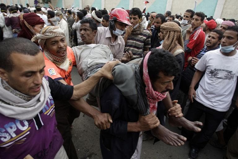Anti-government protestors carry a wounded protestor from the site of clashes with security forces, in Sanaa, Yemen, on Sunday.(AP)