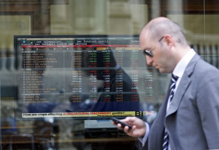 A man passes close to a stock exchange board monitor inside a bank in Milan, Italy.  Worries that Europe's debt crisis will spread to Italy and Spain weighed on markets . (AP)