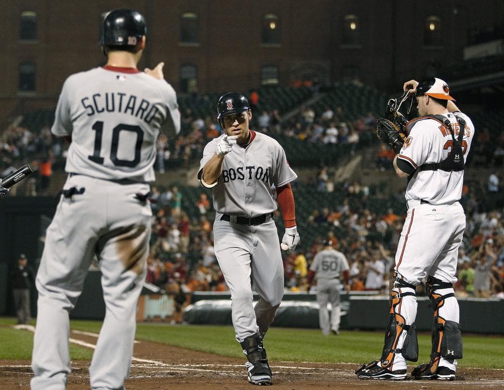 Boston Red Sox&#39;s Jacoby Ellsbury, center, points to teammate Marco Scutaro after both scored on Ellsbury&#39;s home run in the third inning on Tuesday in Baltimore. At right is Orioles catcher Matt Wieters. (AP)