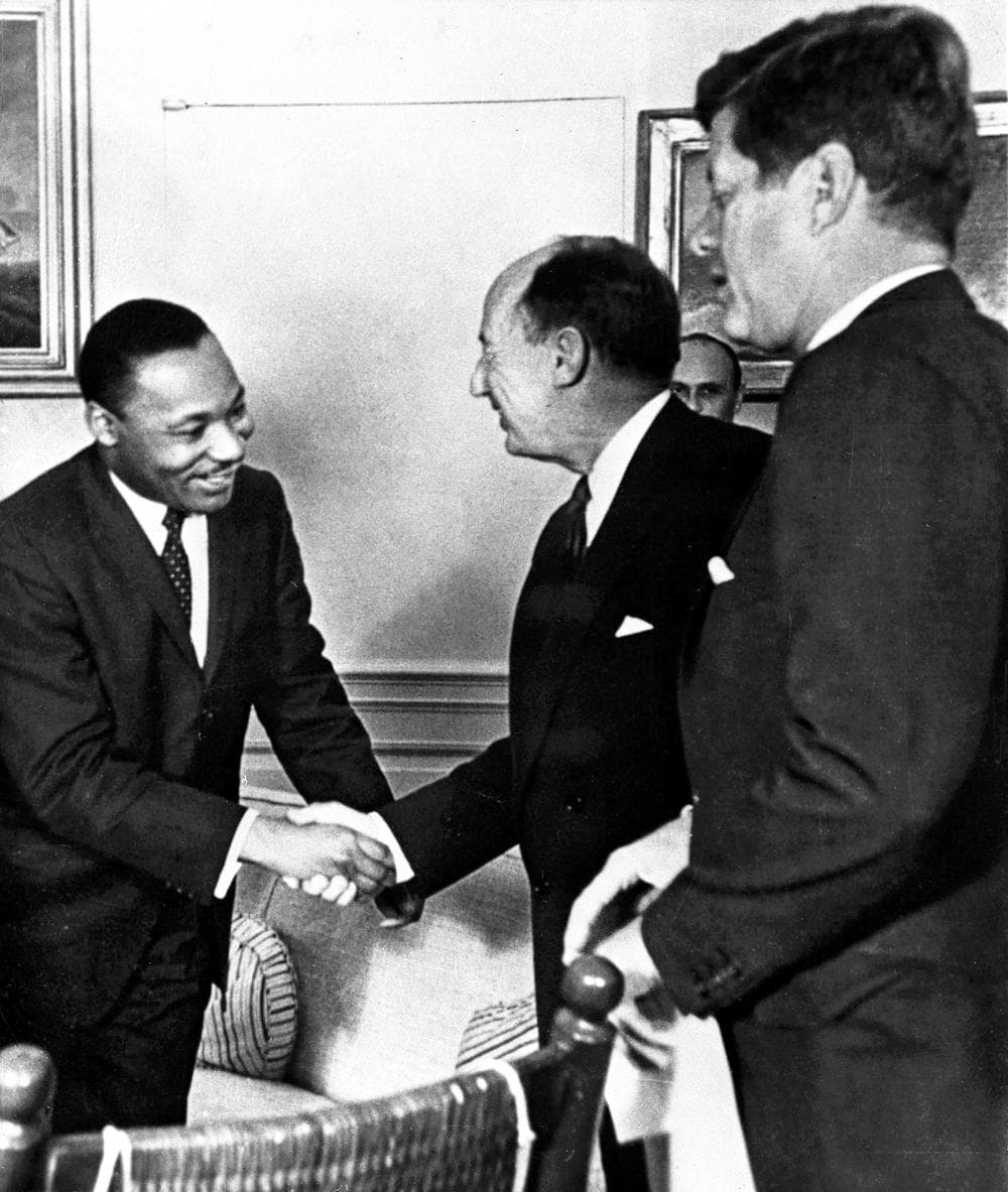 Martin Luther King Jr. shakes hands with Adlai Stevenson, then the U.S. delegate to the United Nations, as President John F. Kennedy looks on, in 1962. (AP)