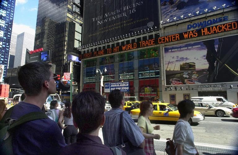 People watch news about the attacks scroll by in New York City's Times Square. (AP)
