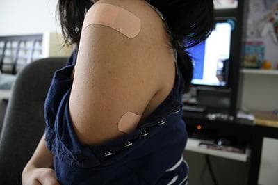 A teenager bares her band-aid after getting the HPV vaccine