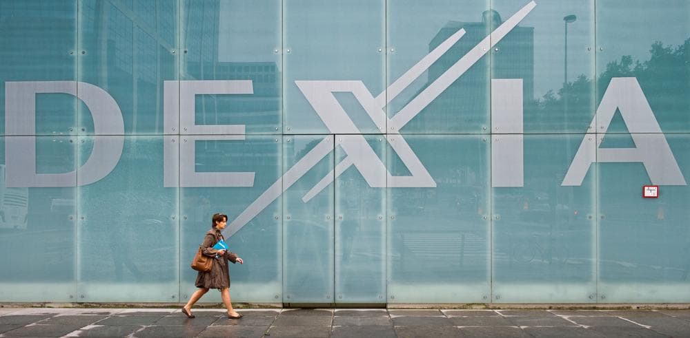 A woman walks by the Dexia corporate headquarters in Brussels. France and Belgium were fighting to prevent Dexia from going under as investors grew increasingly worried over its ability to survive a renewed credit crunch. (AP)