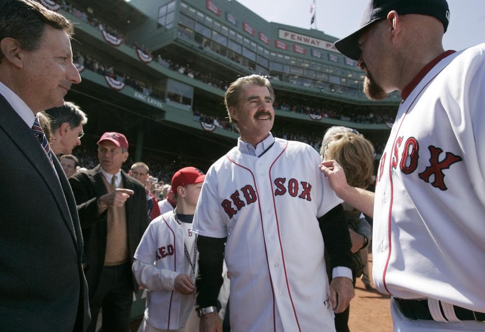 Former Red Sox first baseman Bill Buckner is greeted by Kevin Youkilis and Sox Chairman and co-owner Tom Werner before throwing out the first pitch at Fenway Park's opening day in April. (AP)