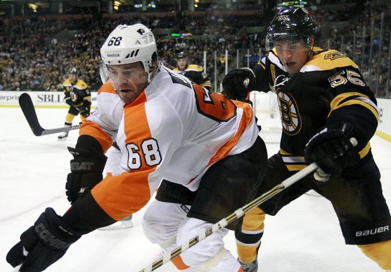 Philadelphia Flyers right wing Jaromir Jagr (68) controls the puck along the boards against Bruins defenseman Johnny Boychuk (55) during the third period of their season-opening game, Thursday. (AP)