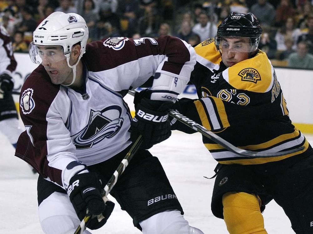 Boston Bruins left wing Brad Marchand, right, fights for position with Colorado Avalanche defenseman Ryan O'Byrne on Monday. (AP)