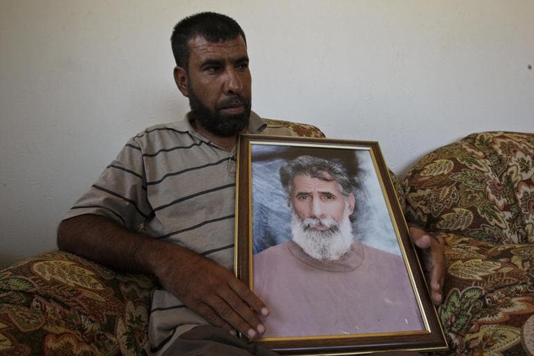 Tayseer Abu Khoussa holds a portrait of his father Mohammad, who has been held in an Israeli jail since 1976, in the village of Um Al Nasser, northern Gaza Strip on Sunday. Mohammad Abu Khoussa, serving three life terms for heading an armed cell that killed several Israeli soldiers in the 1970s, is among the Palestinian prisoners who are to be exchanged for captured Israeli soldier Gilad Schalit. (AP)