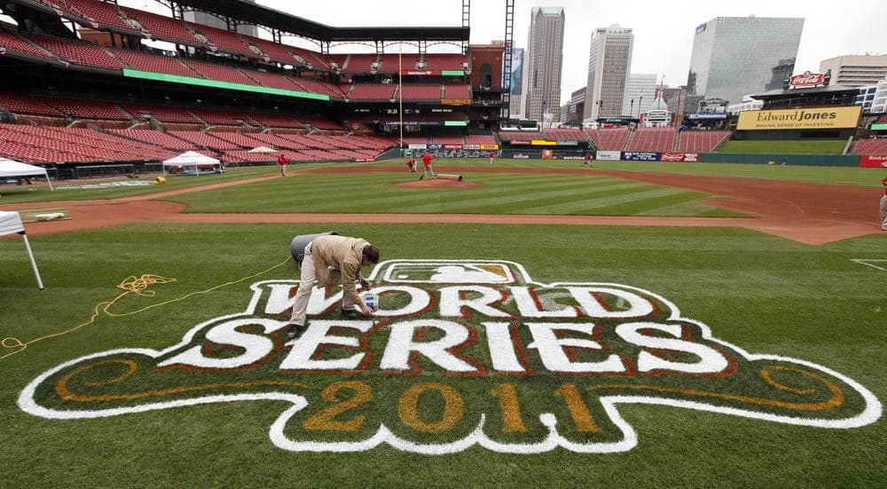 Jim Basler paints a logo on the field at Busch Stadium in preparation for Game 1 of baseball's World Series between the St. Louis Cardinals and the Texas Rangers. (AP)