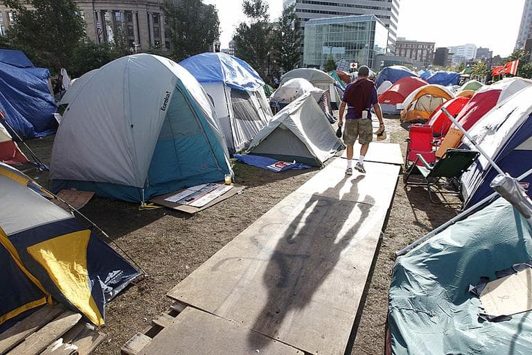 A man walks through a make-shift tent city in the Financial District in Boston. (AP Photo/Charles Krupa)