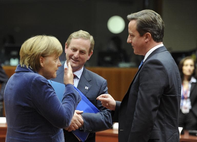 From left, German Chancellor Angela Merkel, Irish Prime Minister Enda Kenny and British Prime Minister David Cameron share a word during a round table at an EU summit in Brussels on Wednesday, Oct. 26, 2011. Chancellor Angela Merkel won the support of German lawmakers to increase the firepower of the eurozone&#039;s bailout fund Wednesday and indicated that private investors like banks should take losses of at least 50 percent on their Greek debt holdings. (AP Photo/Geert Vanden Wijngaert)