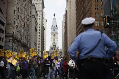 Members of Service Employees International Union march from the encampment at City Hall, center, Tuesday. (AP)