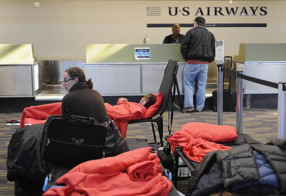 Stranded passengers rest on cots a day after a storm inside at Bradley International Airport in Windsor Locks, Conn., Sunday, Oct. 30, 2011. (AP)