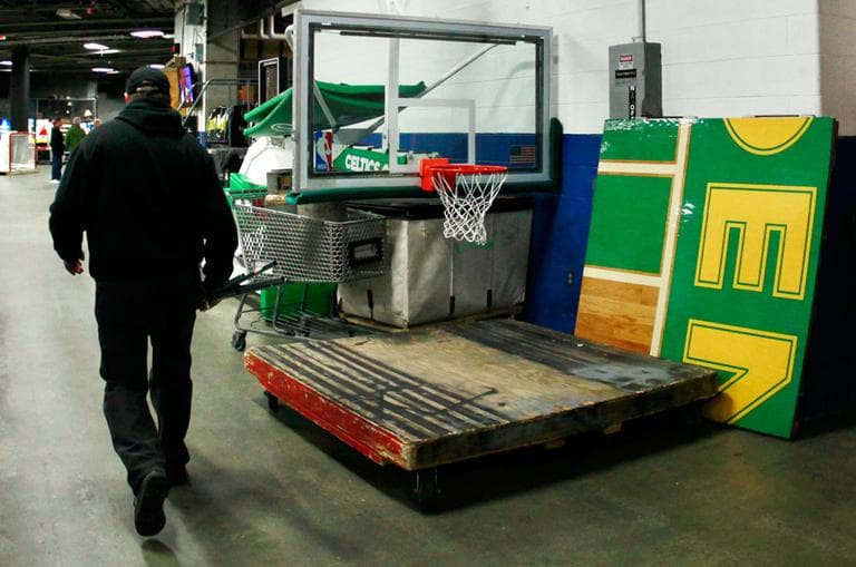 A TD Garden worker walks by a piece of the Boston Celtics parquet floor and a folded-up NBA basket on Oct. 5. The NBA lockout continues into November. (AP)