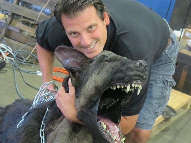 Spooky World co-owner Michael Accomando poses with an animatronic dog. (Andrea Shea/WBUR)