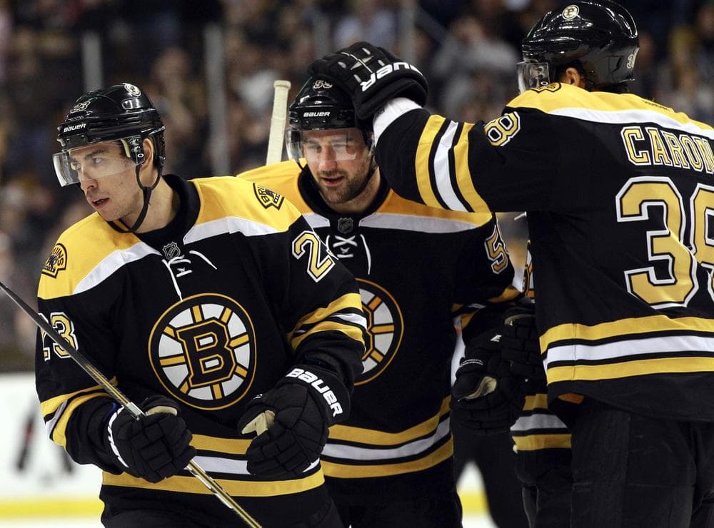 Boston Bruins right wing Jordan Caron (38) celebrates with defenseman Johnny Boychuk, middle, after a goal scored by center Chris Kelly (23) against Ottawa in the second period of the game on Tuesday in Boston. (AP)