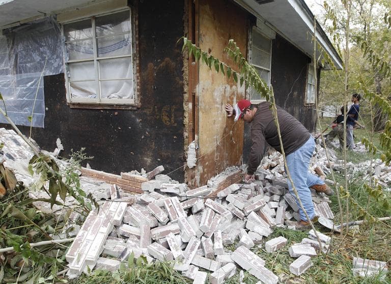 Chad Devereaux works at cleaning up the bricks that fell from three sides of his in-laws home in Sparks, Okla., Sunday, Nov. 6, after two earthquakes hit the area in less than 24 hours. (AP)