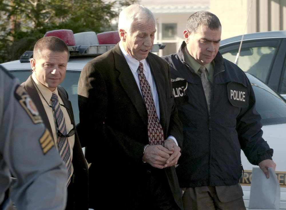 In this photo provided by the Pennsylvania Office of Attorney General, former Penn State football defensive coordinator Gerald &quot;Jerry&quot; Sandusky, center, is escorted in handcuffs to a waiting police car in Bellefonte, Pa. to be taken to the office of a Centre County Magisterial District judge on Saturday, Nov. 5, 2011. Sandusky is charged with sexually abusing eight young men. (AP/Pennsylvania Office of Attorney General, Commonwealth Media Services)
