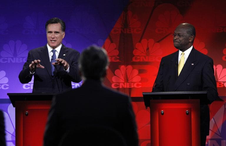 Republican presidential candidate and former Massachusetts Gov. Mitt Romney, left, speaks as Herman Cain listens during a Republican presidential debate at Oakland University in Auburn Hills, Mich., Wednesday.  (AP)