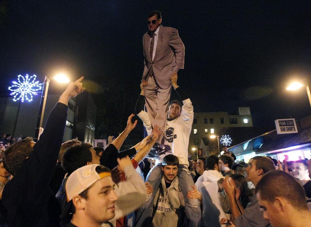 Penn State students and others gather off campus, one holding a cutout of football coach Joe Paterno, Wednesday. (AP)