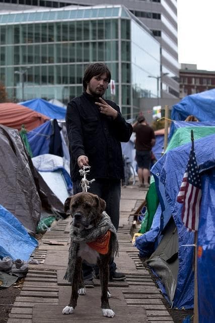 Occupy Boston protester Dave and his dog pose on one of the &#039;streets&#039; of the Occupy Boston campsite. (Luke Boelitz for WBUR)