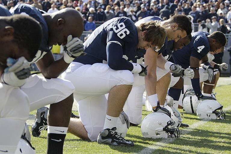 Penn State football players kneel in prayer before an NCAA college football game against Nebraska in State College, Pa. (AP Photo/Gene J. Puskar)