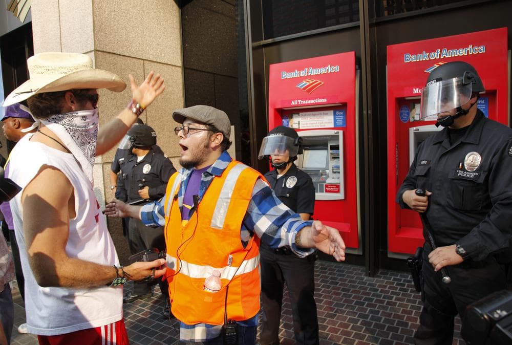Occupy Los Angeles organizers, center, keep protesters away from confronting Los Angeles police officers guarding a Bank of America ATM in Los Angeles, Thursday. (AP)