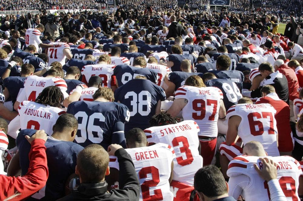 Penn State and Nebraska football players gather at midfield for a prayer before Saturday's game in State College, Pa. (AP)