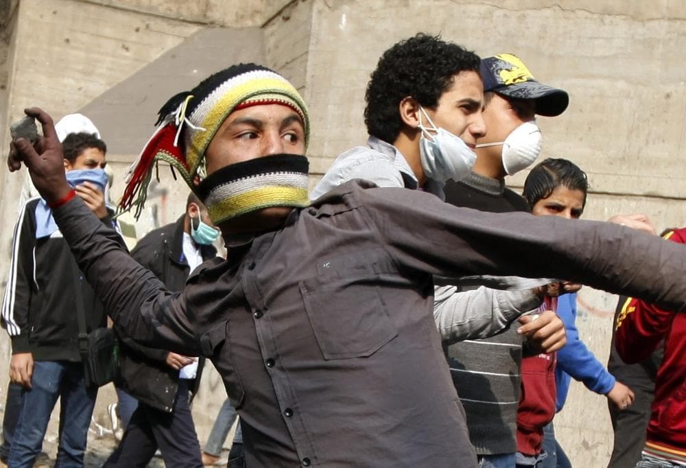 A protester throws stones during clashes with the Egyptian riot police near Tahrir square in Cairo, Egypt on Tuesday. (AP)