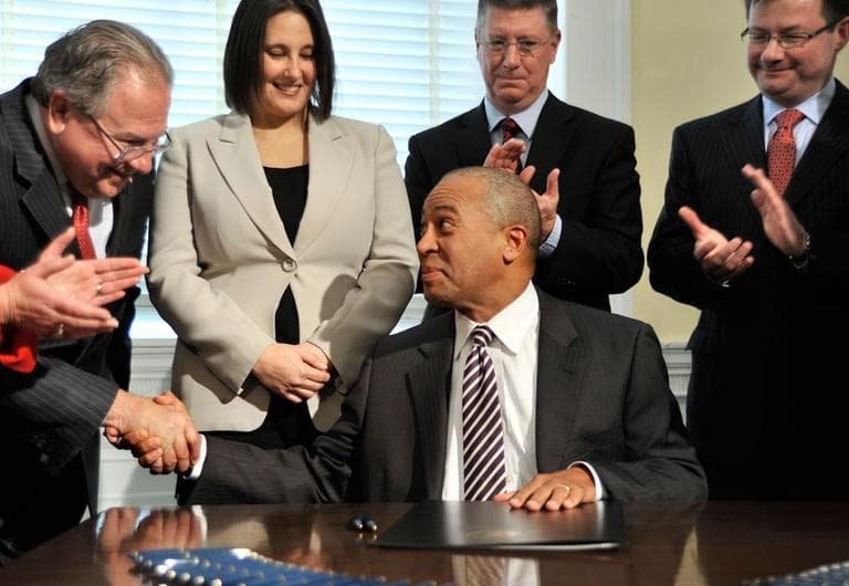 As others look on, Gov. Deval Patrick shakes hands with Speaker Robert DeLeo after signing a bill legalizing casino gambling in Massachusetts Tuesday. (AP)