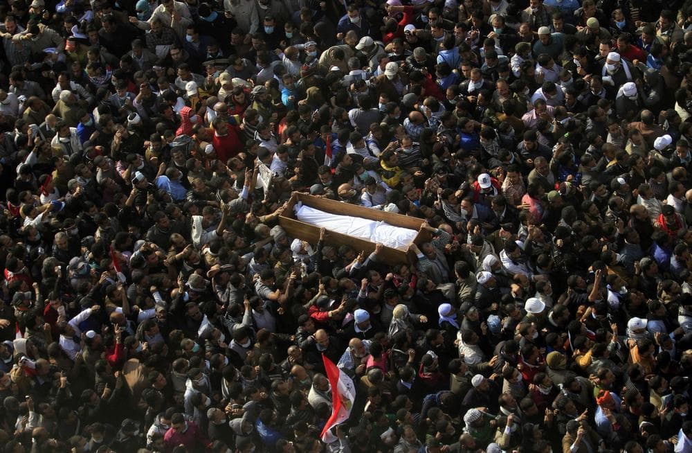 Egyptians carry a body of a protester, killed in recent clashes with the Egyptian riot police, at Tahrir square, during his funeral on Tuesday in Cairo, Egypt. (AP)