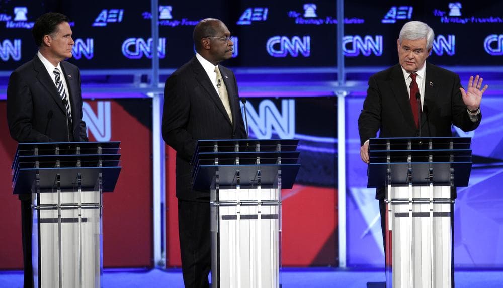 Republican presidential candidates former Massachusetts Gov. Mitt Romney and businessman Herman Cain listen to former House Speaker Newt Gingrich at a Republican presidential debate in Washington. (AP)
