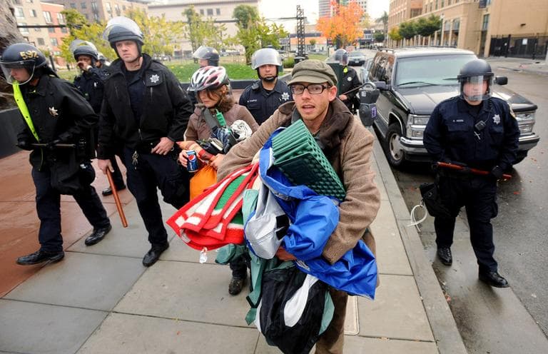 Police officers evict Occupy Oakland protesters from their camp at Telegraph Avenue and 19th Street in Oakland, Calif., on Sunday, Nov. 20, 2011. The previous night, protesters tore down a fence surrounding a vacant lot to establish the 20-tent encampment. (AP)