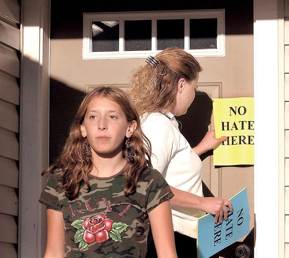Jill Summers, right, and her daughter, leave a flier that says &quot;No hate here&quot; in 2006 on a neighbor&#039;s door, in Kalispell, Mont. The arrival of a white nationalist family of April Gaede has prompted neighbors to distribute the fliers. (AP)