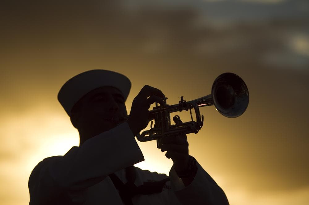 Navy Region Hawaii Honor Guard seaman plays taps at sunset during the internment ceremony for Pearl Harbor survivor Lee Soucy, Tuesday, Dec. 6, 2011 in Honolulu. (AP)
