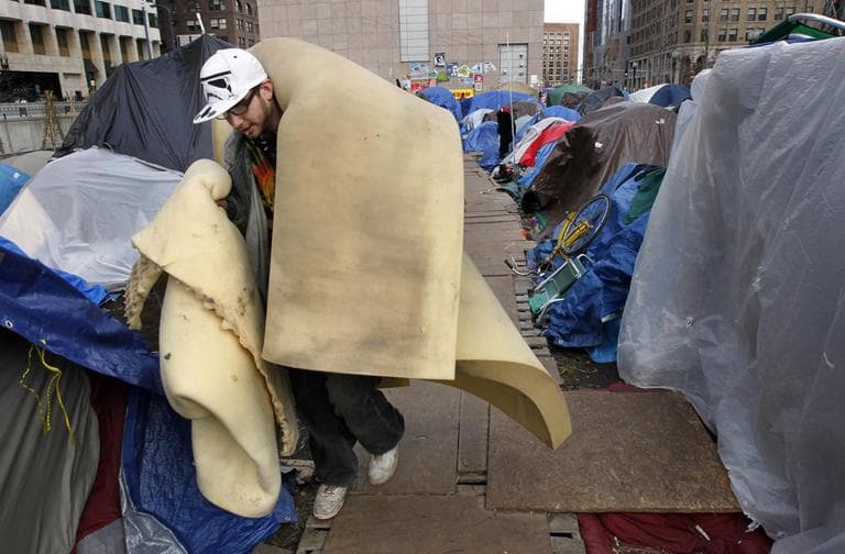 Occupy protester Steven Pimental, of Boston, removes foam rubber from his tent at the Dewey Square encampment, in Boston, Monday. (AP)