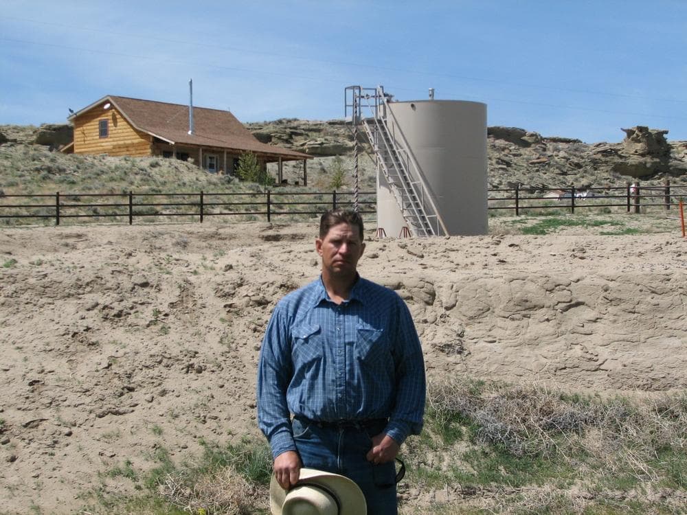 John Fenton, a farmer who lives near Pavillion in central Wyoming, near a tank used in natural gas extraction, in background. Fenton and some of his neighbors blame hydraulic fracturing, or &quot;fracking,&quot; for fouling their well water. (AP)