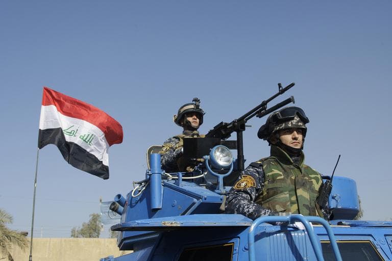 In this Tuesday, Nov. 22, 2011 photo, The Iraqi flag waves while federal Police parade in Baghdad, Iraq. In ways big and small, the signs of American influence on the Iraqi military are unmistakeable after years of training to give them the skills to defend their country and the professionalism to do it differently than Saddam Hussein's forces did. (AP)