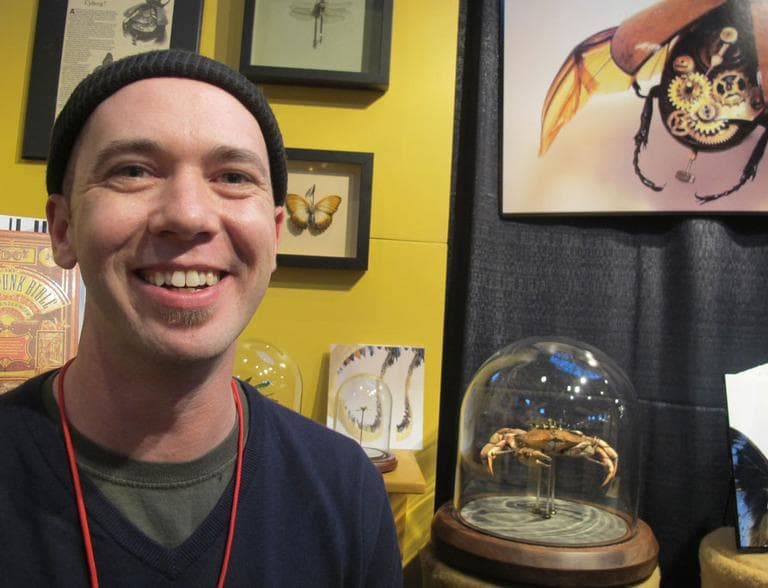 Maine artist Mike Libby, shown at Craftboston, makes intricate insect sculptures using real bugs. (Andrea Shea/WBUR)
