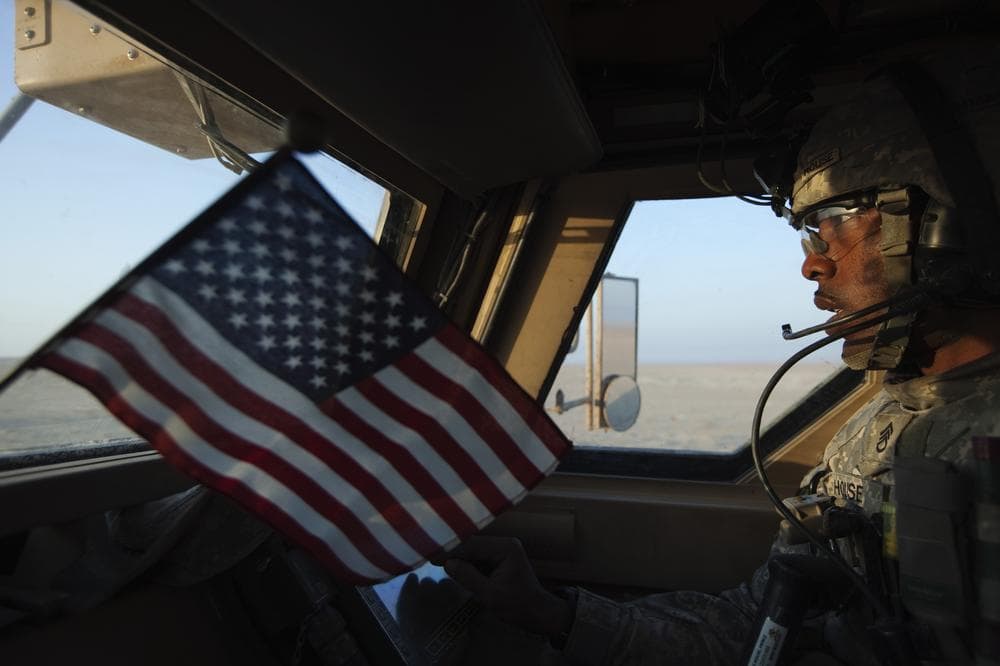 Staff Sergeant Prince House from the 3rd Brigade Combat Team, 1st Cavalry Division rides in a Mine Resistant Ambush Protected (MRAP) vehicle on the way to cross the Kuwaiti border as part of the last U.S. military convoy to leave Iraq Sunday. (AP)